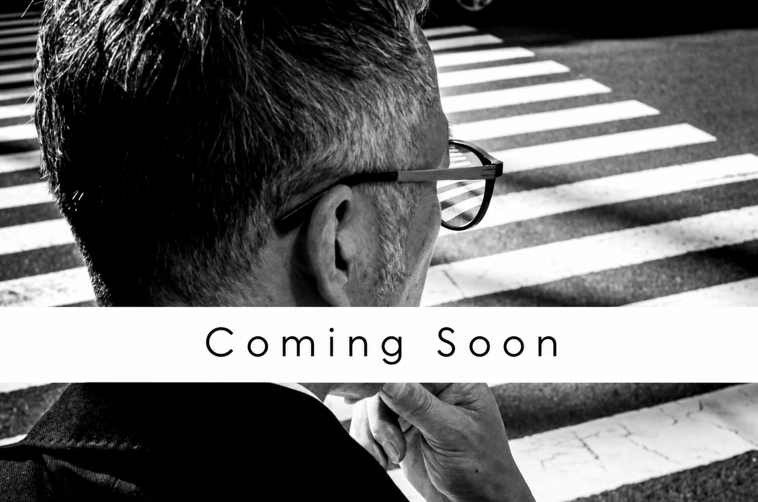 Black-and-white street photograph of a man at a crossing